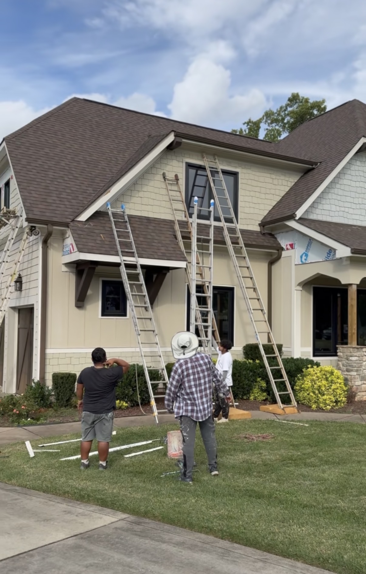 Painters with ladders working on siding during a Mooresville exterior repaint