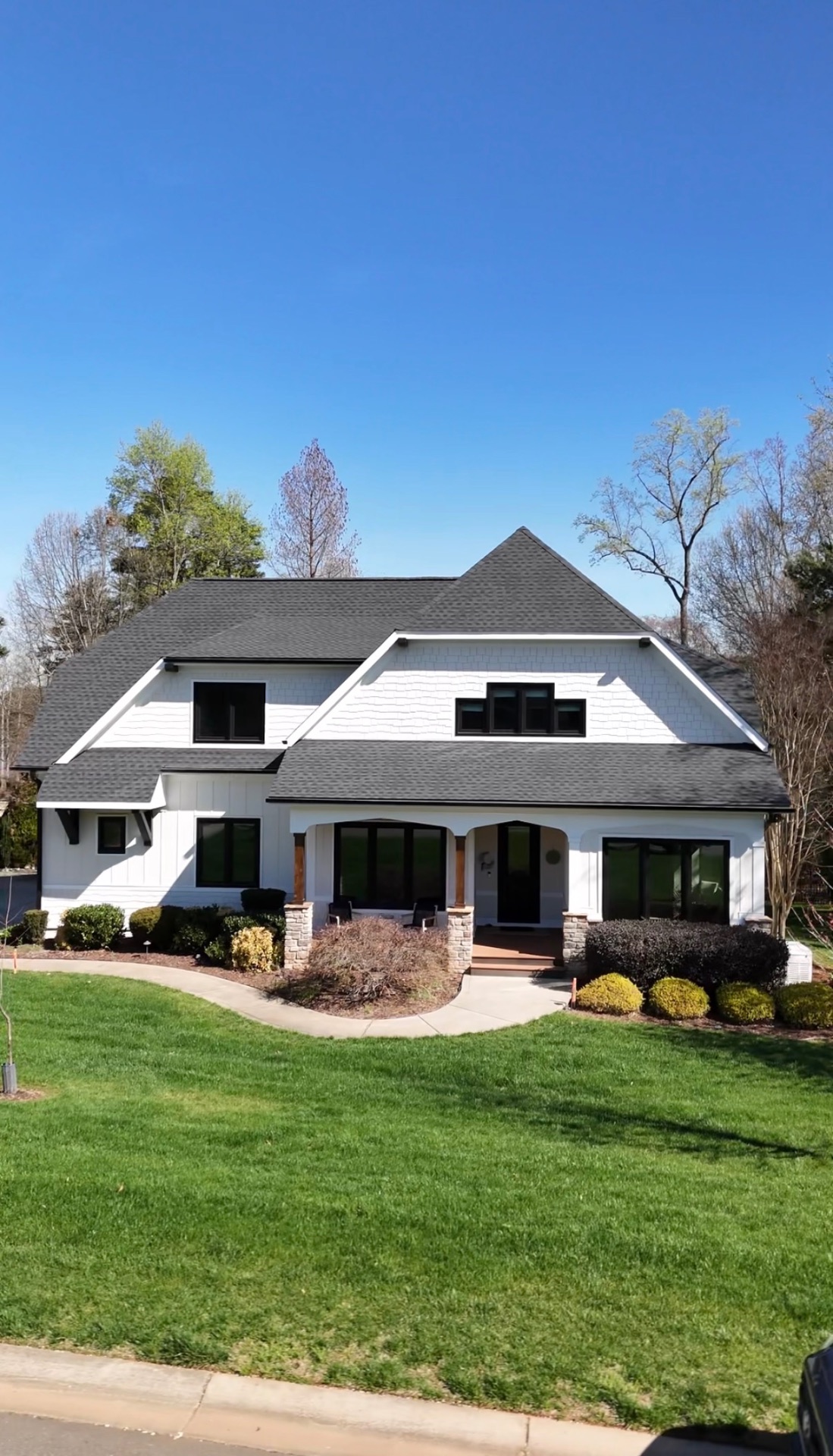 Finished exterior repaint of a Lake Norman home in Mooresville with white siding and black-trimmed windows
